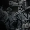 Personal médico operando a un paciente junto a un Tablero de Aislamiento